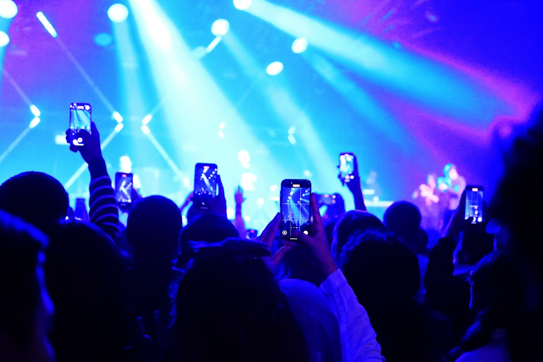 Concert crowd filming a live performance on phones, illustrating the creator economy